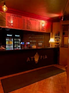 Die Atopia-Bar mit Getränkekarte und warmer Beleuchtung